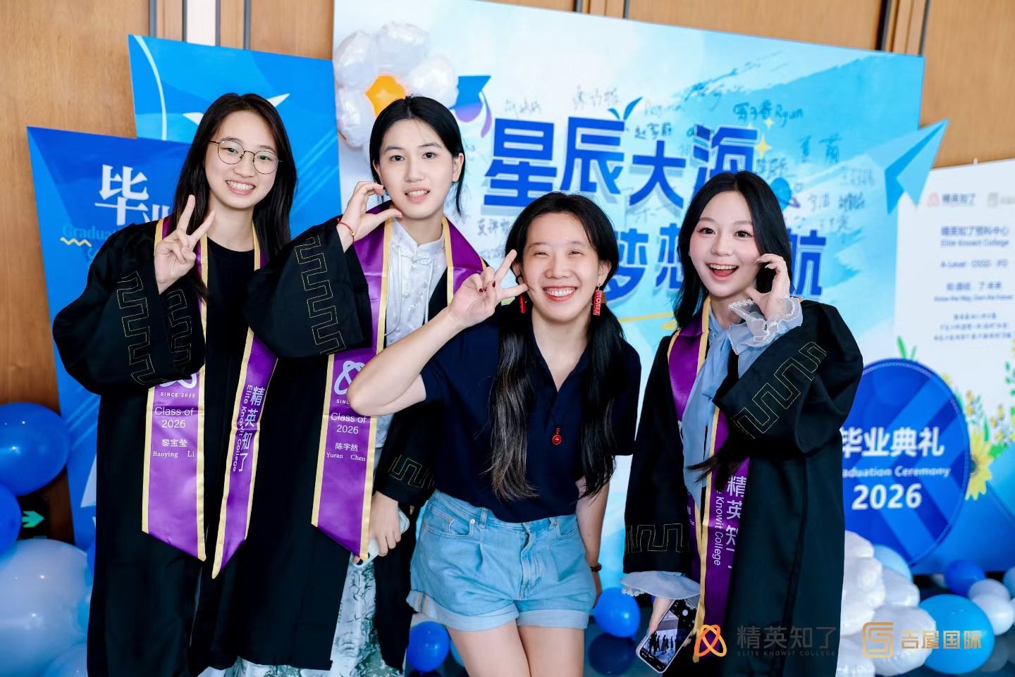 精英知了毕业生与老师在星辰大海签名墙前合影
